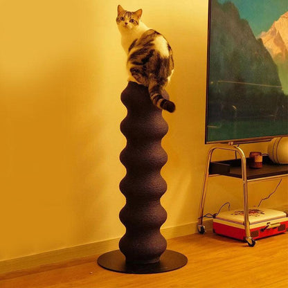 Cat perched on top of a vertical large cat scratching post climbing tree in a cozy living room setting.