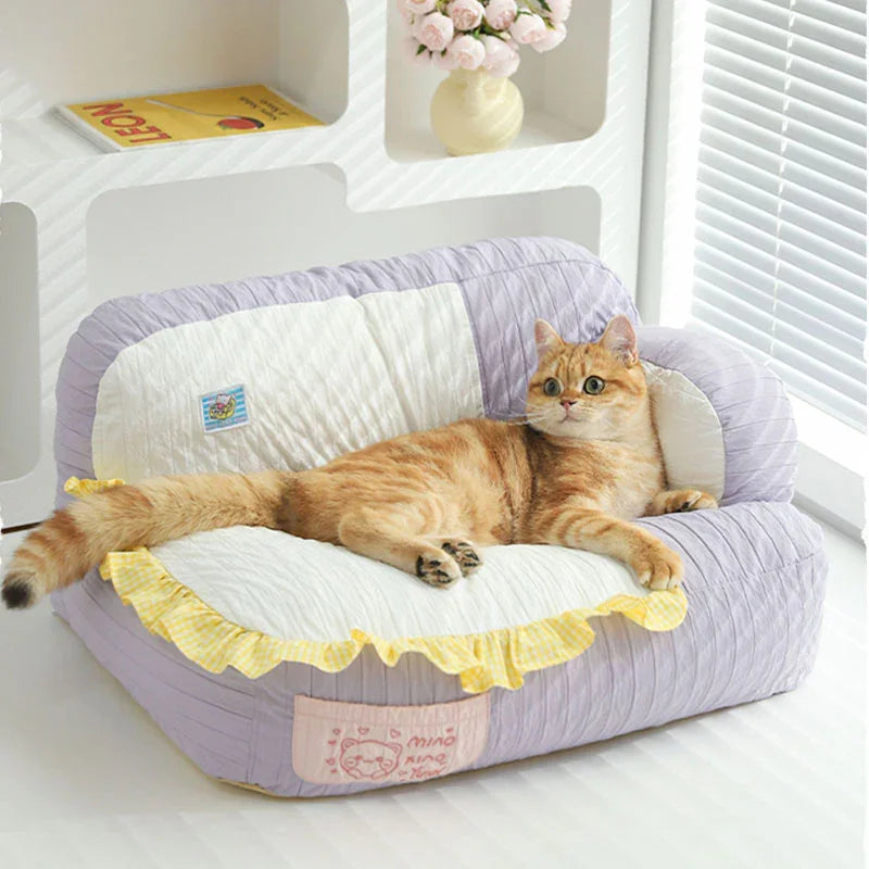 Soft & Cozy Cat Sofas — Perfect Lounging Spots for Happy Indoor Cats with a relaxed cat lounging on a purple and white sofa.
