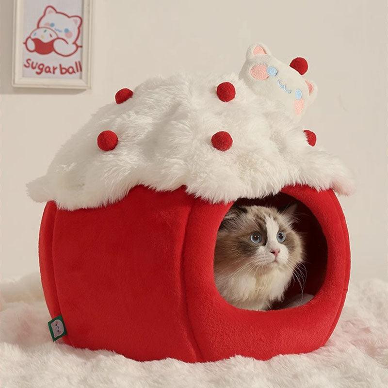 Snowball & Strawberry Cat Cave Bed — Soft & Cozy with a cat peeking out from inside a red strawberry-shaped bed.