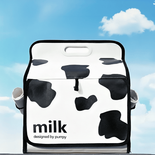 KtKitty Cute Milk Cat Backpack with a creative milk carton design and transparent window. The image shows the backpack placed outdoors with a realistic sky background and a small cloud, highlighting the unique 3D shape and durable pet travel carrier features.