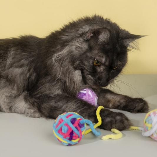 Close-up view of the yarn ball cat toy with a bell for added excitement.