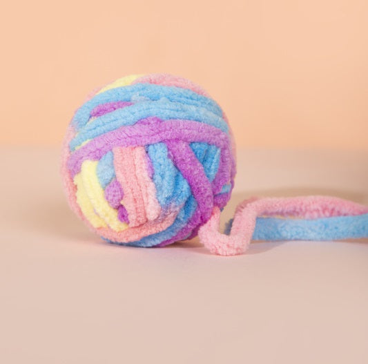 Close-up view of the yarn ball cat toy with a bell for added excitement.