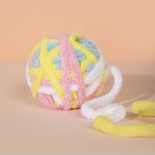 Kitten playing with the yarn ball toy, perfect for teething and chewing.