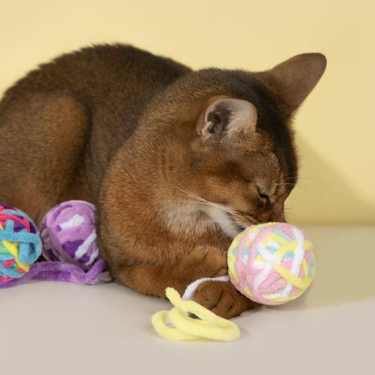 A durable yarn ball cat toy with bell for chewing and teething kittens.