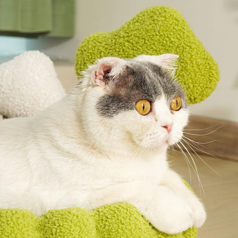 Cozy cat lounging on a green scratching bed, showcasing a Solid Wood Rattan Cat Tree Tower for comfort and claw care.